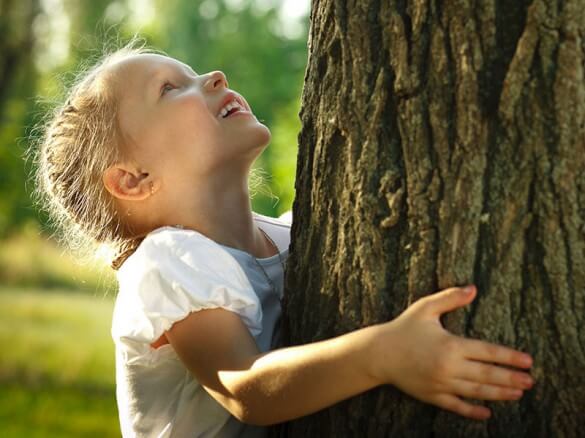 Kind umarmt Baum